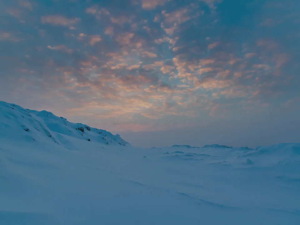 Wind-shaped snow on Lommoltunturi fell at blue hour, pink clouds overhead, in January